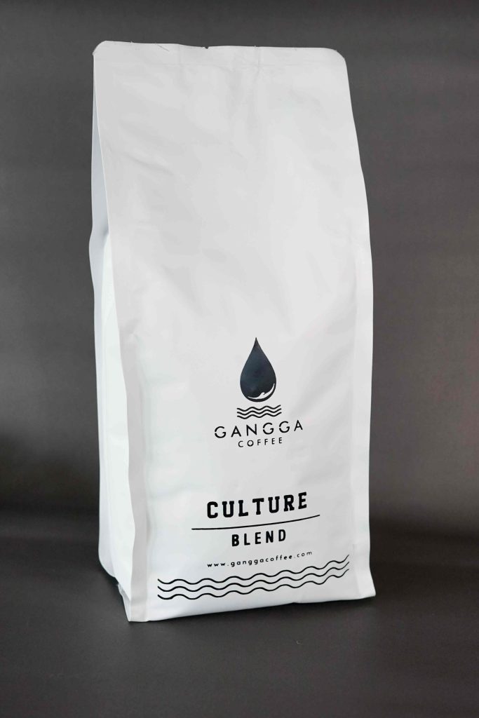 Culture Blend coffee packaging from Gangga Coffee featuring a minimalist white bag design with black logo branding, specialty roasted coffee blend, standing pouch packaging, premium artisan coffee product, clean modern coffee packaging, Indonesian specialty coffee, retail coffee bag display. 